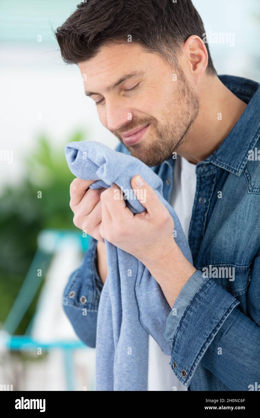 houseman is smelling clean laundry Stock Photo