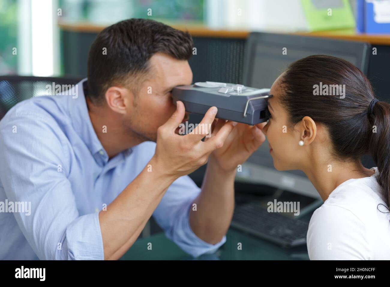 ophthalmologist measuring intraocular pressure of young woman in clinic Stock Photo