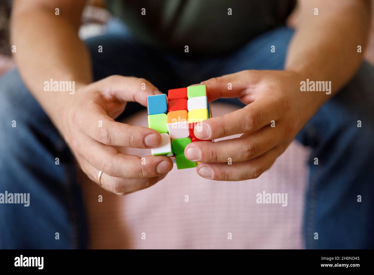 Moscow Russia October 10, 2021. Male hands holding Rubik's cube close up Rubik's cube invented by a Hungarian architect Erno Rubik in 1974. Stock Photo