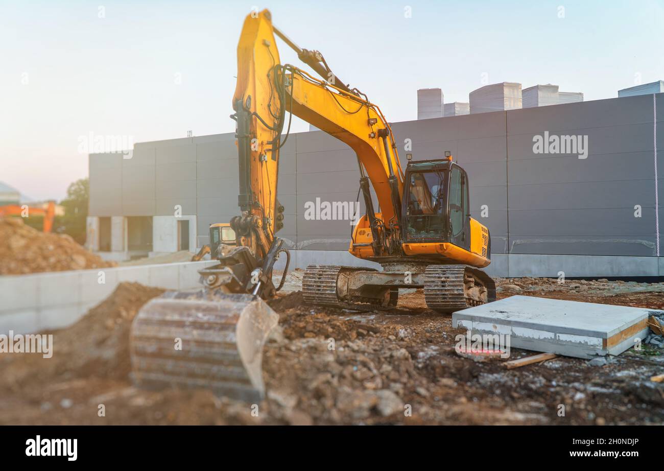 Yellow excavator working on the construction site Stock Photo - Alamy