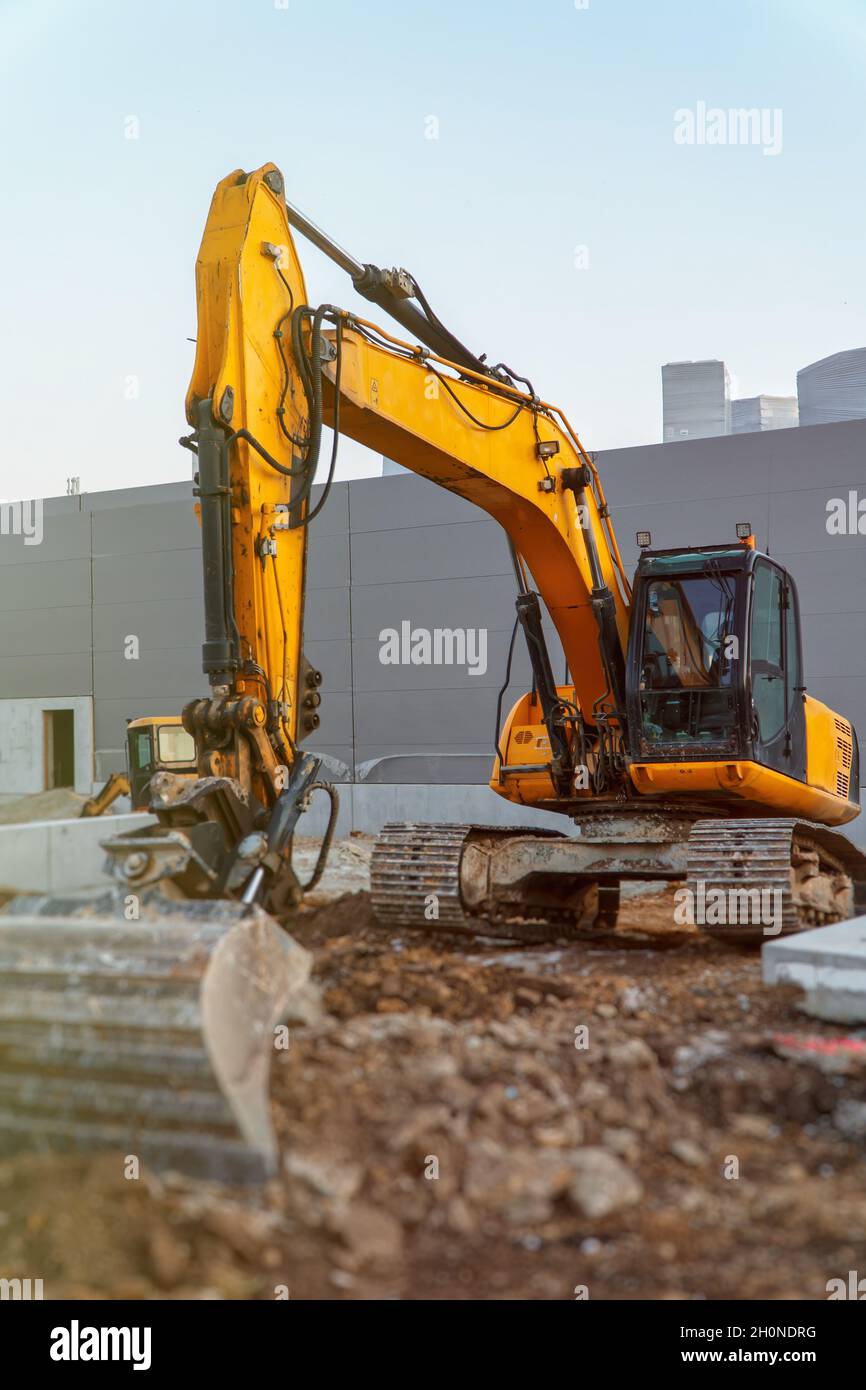 Yellow excavator working on the construction site Stock Photo - Alamy