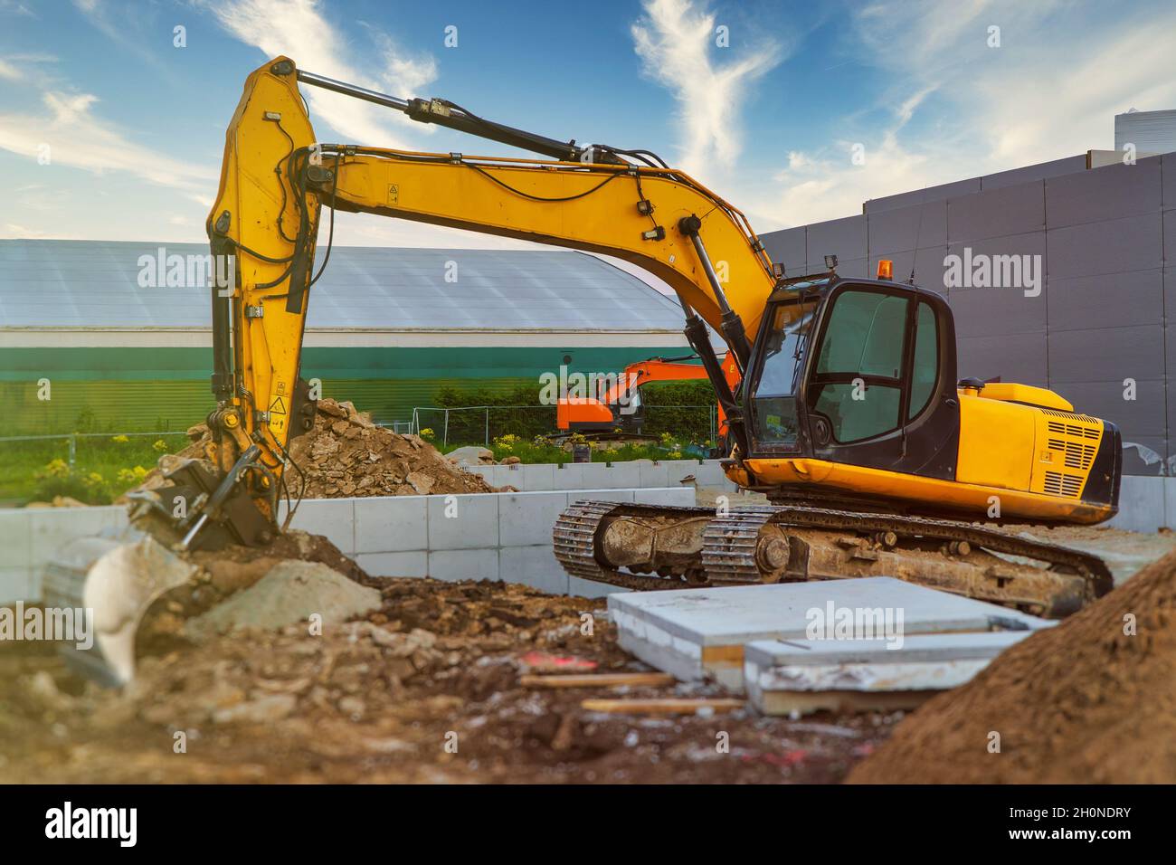 Yellow excavator working on the construction site Stock Photo - Alamy