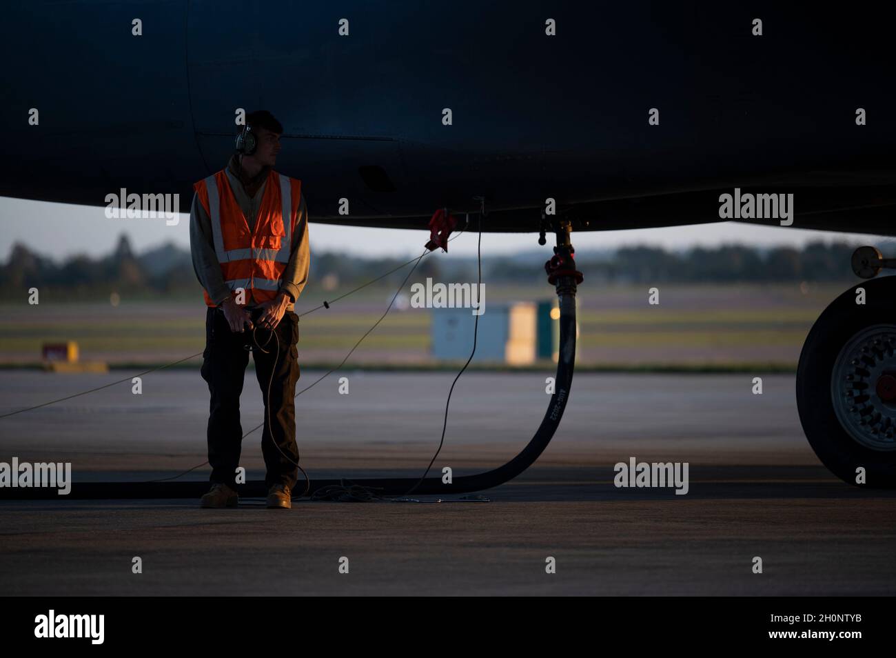 A fuels specialist assigned to the 9th Expeditionary Bomb Squadron, stands by while a B-1B Lancer is being refueled at RAF Fairford, United Kingdom, Oct 11, 2021. Fuels specialists support Bomber Task Force Europe missions by managing refueling operations necessary to support a variety of training exercises. (U.S. Air Force photo by Airman 1st Class Josiah Brown) Stock Photo