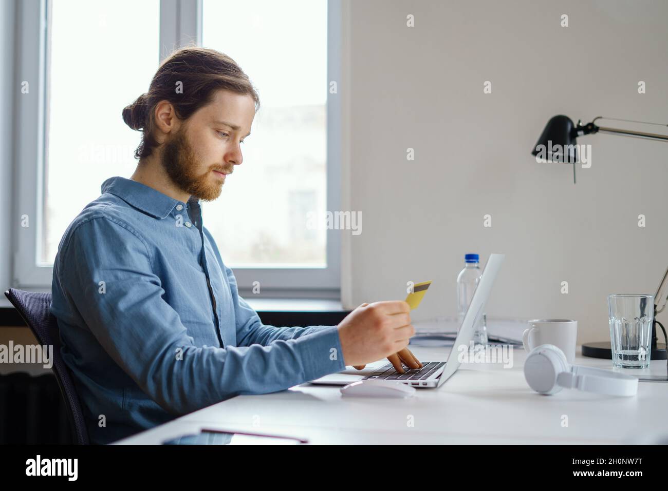 Employee data privacy at work. Booking and purchasing with credit card online at workspace Stock Photo