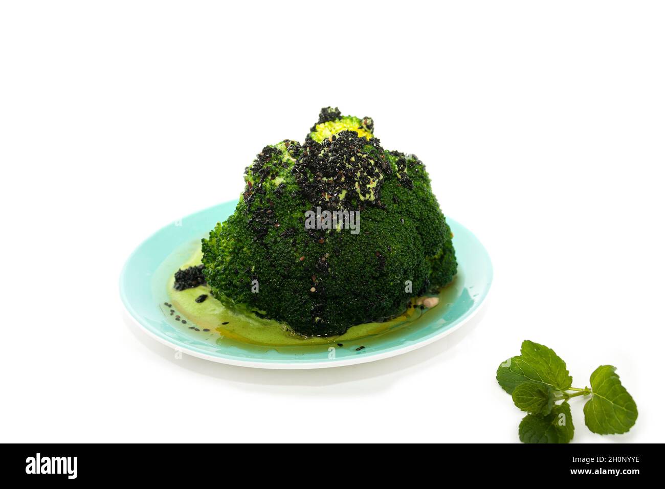 Vegetarian food Broccoli with Chiltepin topped with a vegetable peppermint gravy sauce and black sesame isolated on white bacground in Mexico Stock Photo