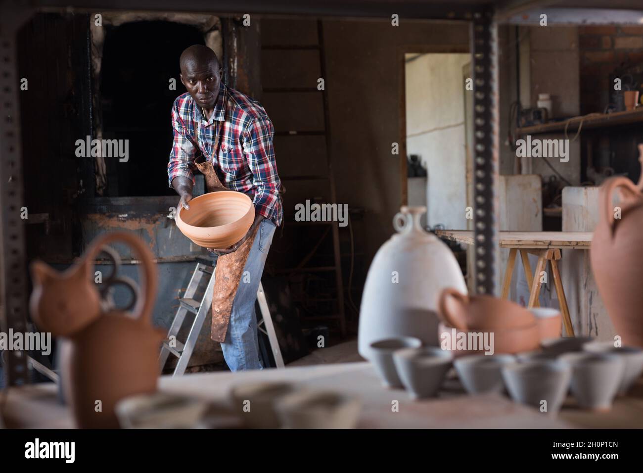 Artisan working in pottery workshop Stock Photo - Alamy