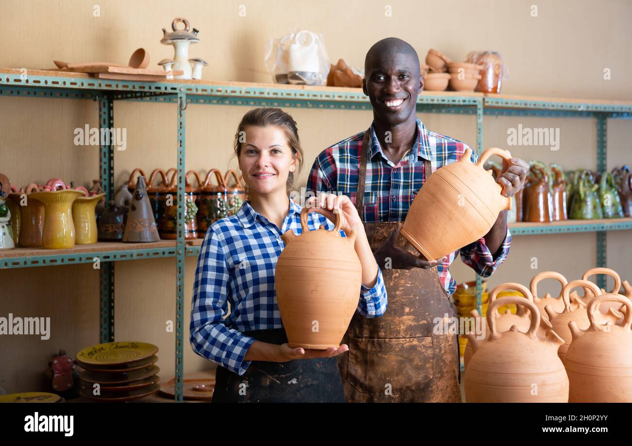 Two potters posing in pottery workshop Stock Photo - Alamy