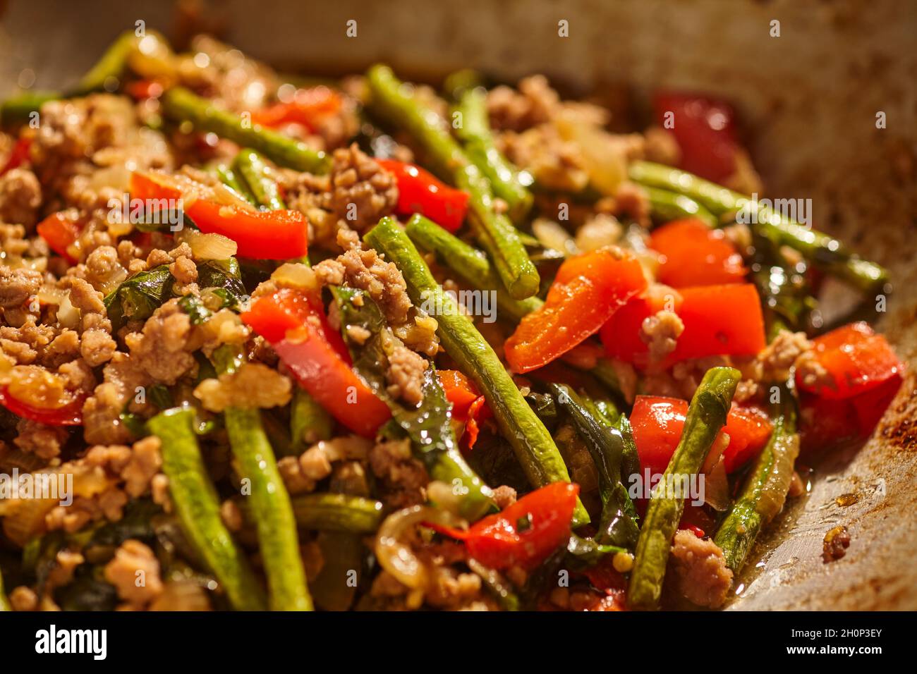 Pad Kra Pao, the Thai basil stir-fry made with pork in a stainless steel wok Stock Photo