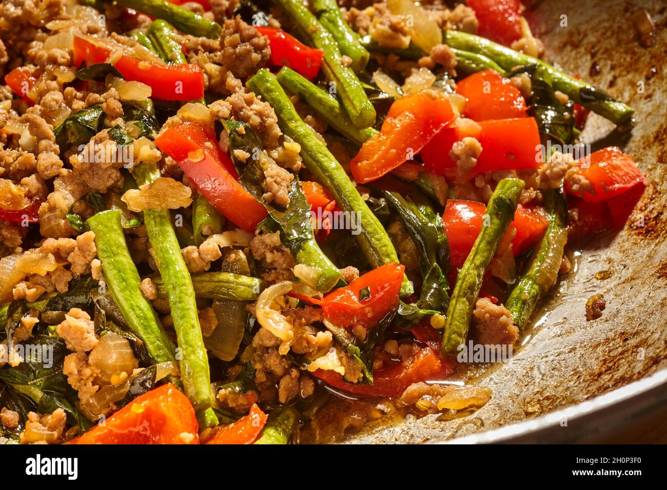 Pad Kra Pao, the Thai basil stir-fry made with pork in a stainless steel wok Stock Photo