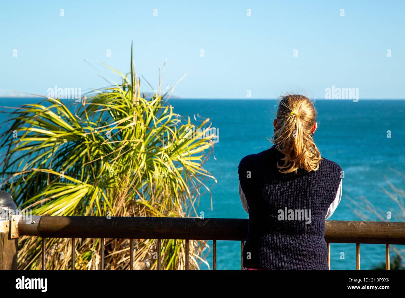 A fair haired lady pondering the ocean. Stock Photo