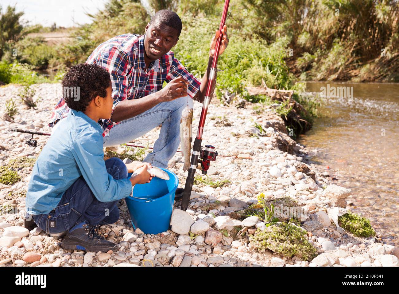 Boy and his father holding fish on hook Stock Photo