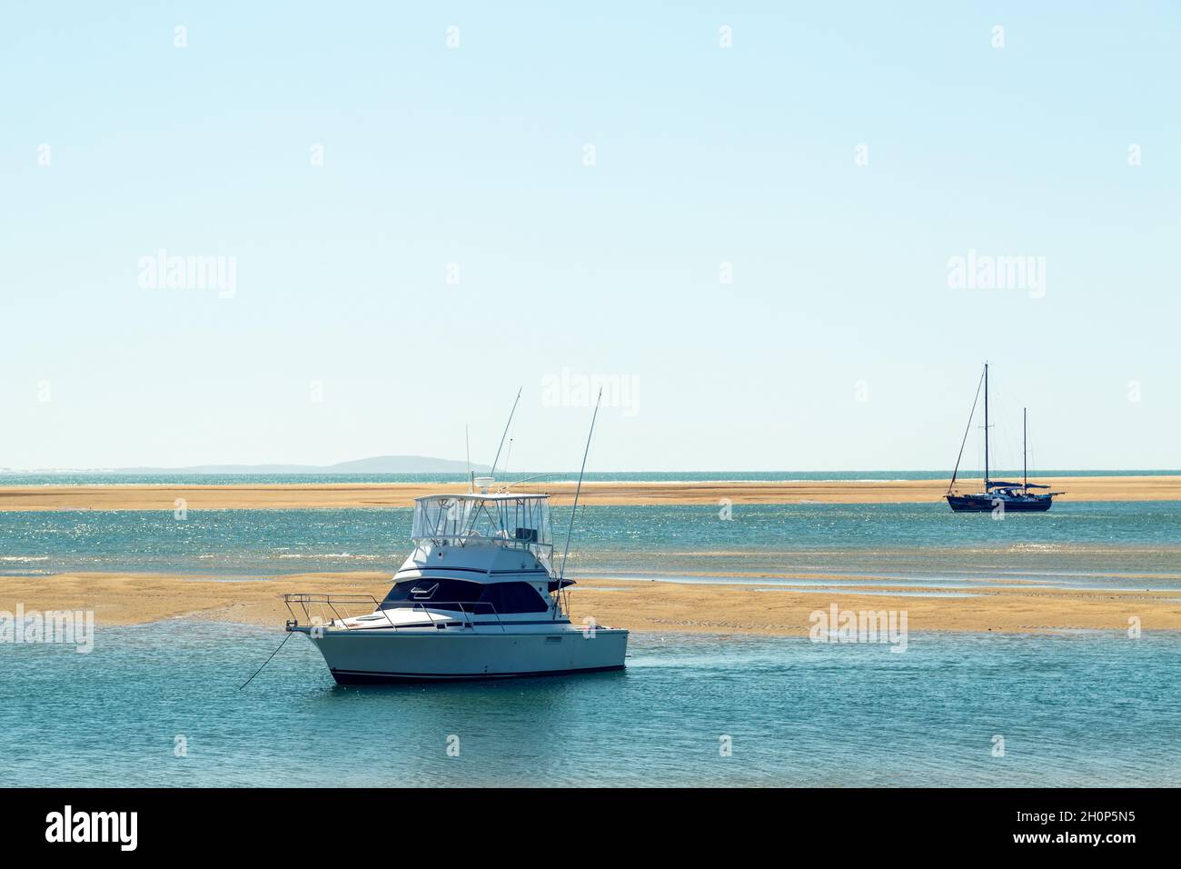 Cruising boats anchored in a tidal estuary. Stock Photo