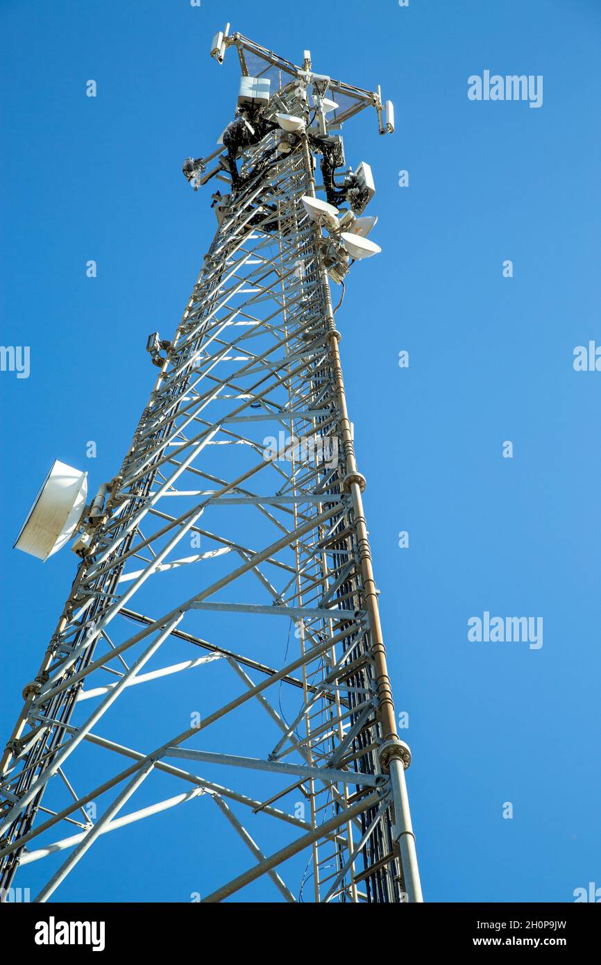 Looking up at a telecommunications tower under clear blue sky. Stock Photo