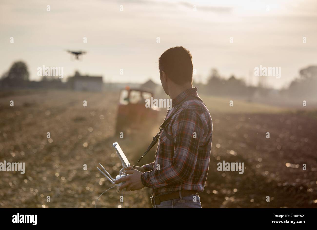 Attractive farmer navigating drone above farmland. High technology innovations for increasing productivity in agriculture Stock Photo
