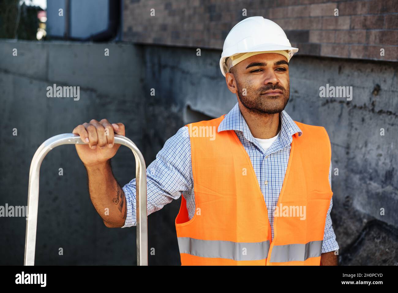 Professional builder carrying metal ladder, close up Stock Photo