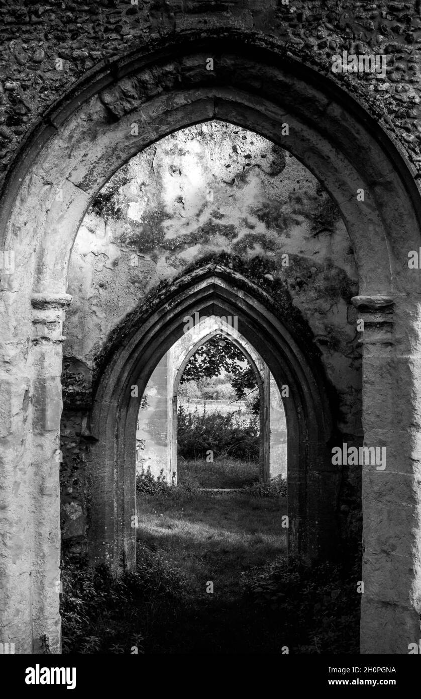 Black and white image of three archways of John the Baptist church Stanton Suffolk. Showing ruined stonework and windows. No people. Stock Photo