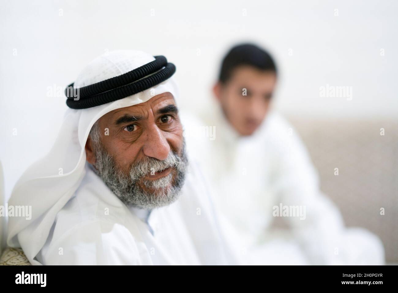 Abu Ahmad alEnezi, a stateless sits with his son at their home in
