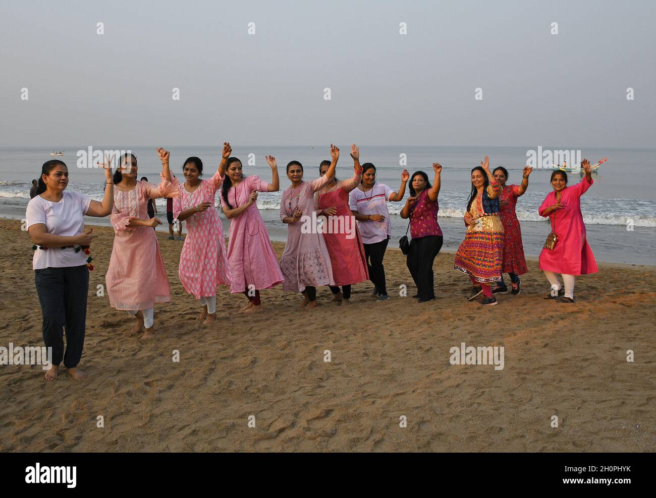Mumbai, India. 14th Oct, 2021. Women wearing pink dresses perform Garba dance on Juhu beach in Mumbai.Navratri is a Hindu festival spanning nine nights. devotees pray to goddess Durga during the nine nights & perform Garba dance. Credit: SOPA Images Limited/Alamy Live News Stock Photo