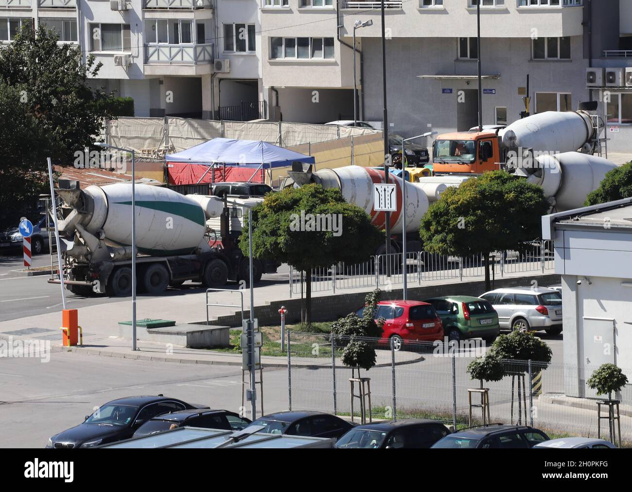 Heavy concrete trucks are waiting near a construction site in the city, trucks are making heavy air pollution Stock Photo