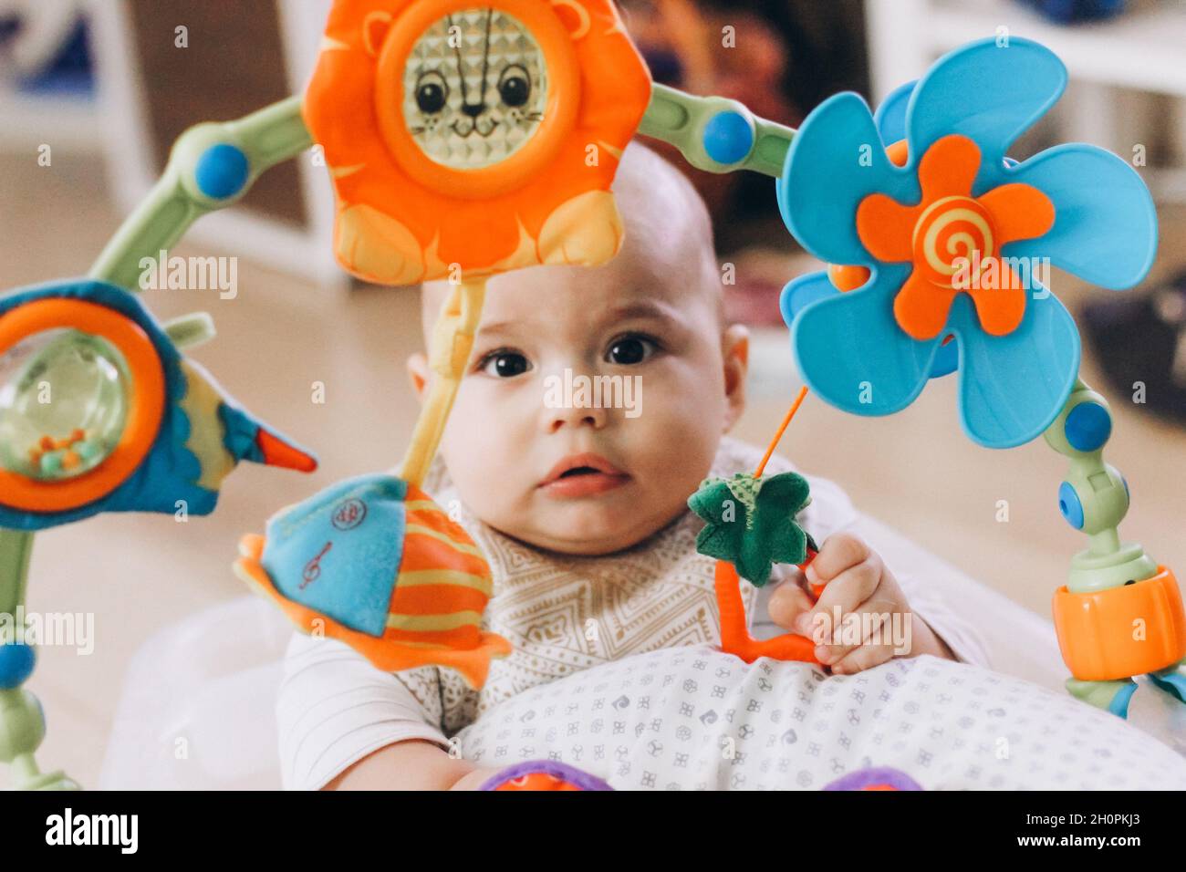 Cute chubby baby playing with colorful toys. Stock Photo