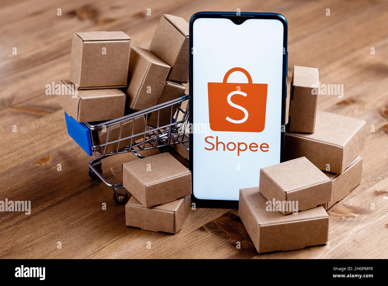 Shopee is e-commerce technology company. Smartphone with Shopee logo on the  screen, shopping cart and parcels Stock Photo - Alamy