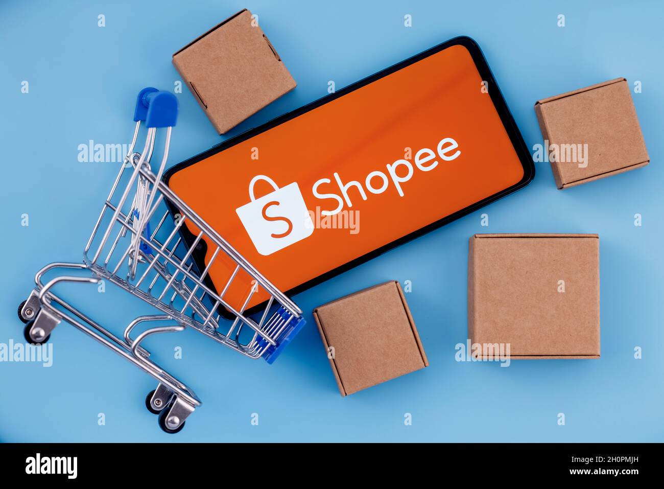 Shopee is e-commerce technology company. Smartphone with Shopee logo on the  screen, shopping cart and parcels Stock Photo - Alamy