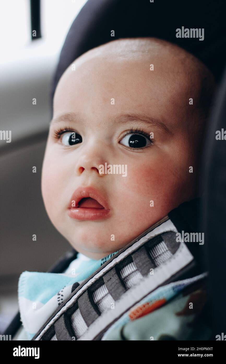 Sweet infant in the car sits in child seat. Safe driving. Baby care