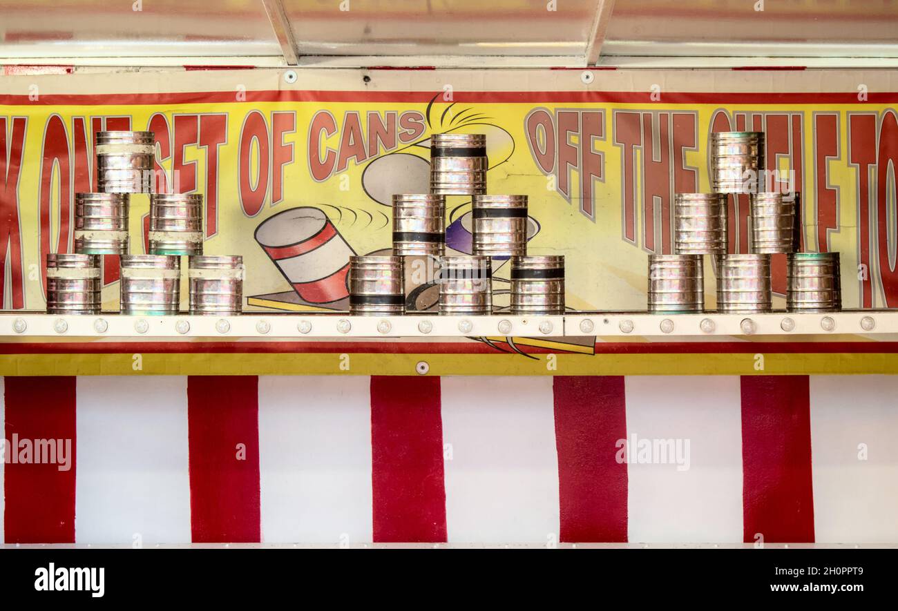Knock Cans Down For A Prize Stall At A funfair With Cans On A Shelf in A Pyramid Shape, UK Stock Photo