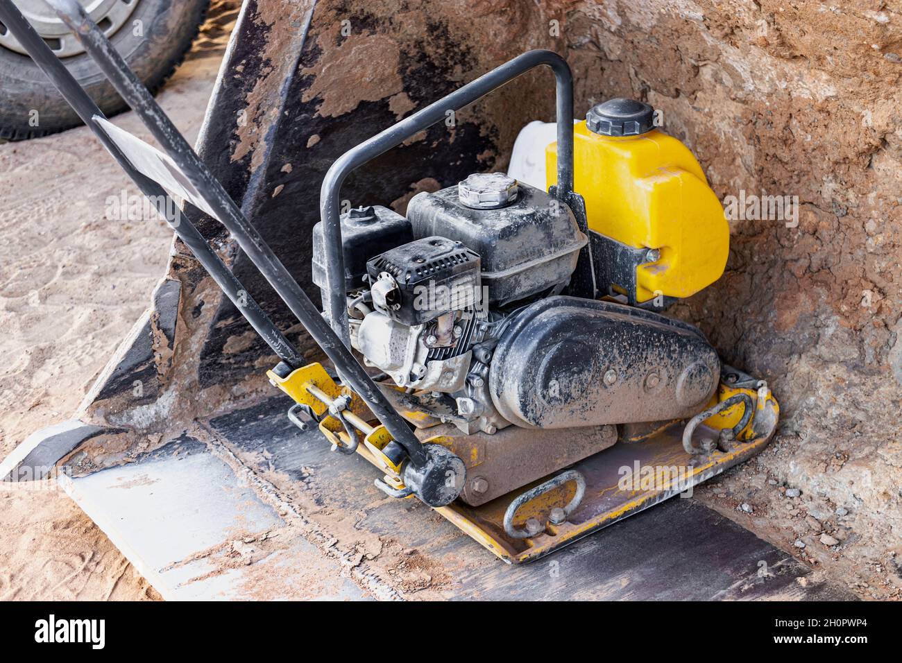 Vibratory rammer with vibrating plate on a construction site. Compaction of  the soil before laying paving slabs. Close-up Stock Photo - Alamy