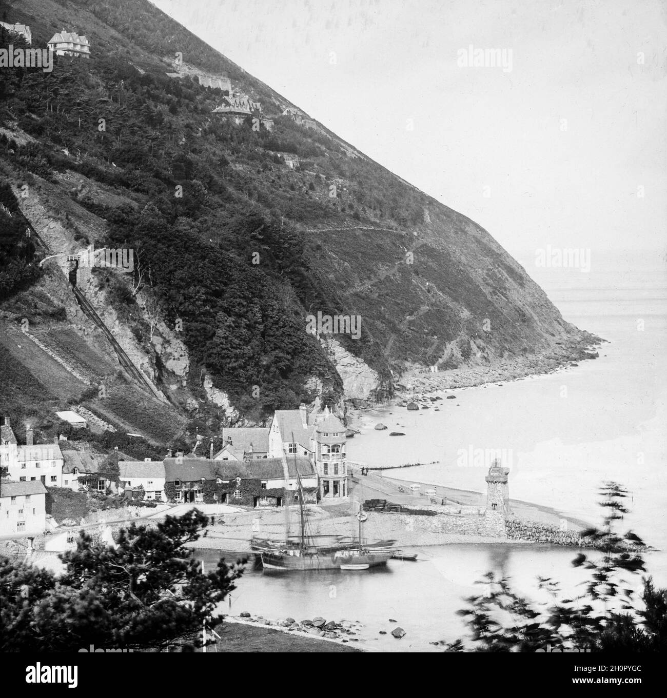 Vintage late Victorian black and white photograph showing the harbour at Lynmouth in Devon, England. On view is the Rhenish Tower along with sailing boats of the era. Stock Photo