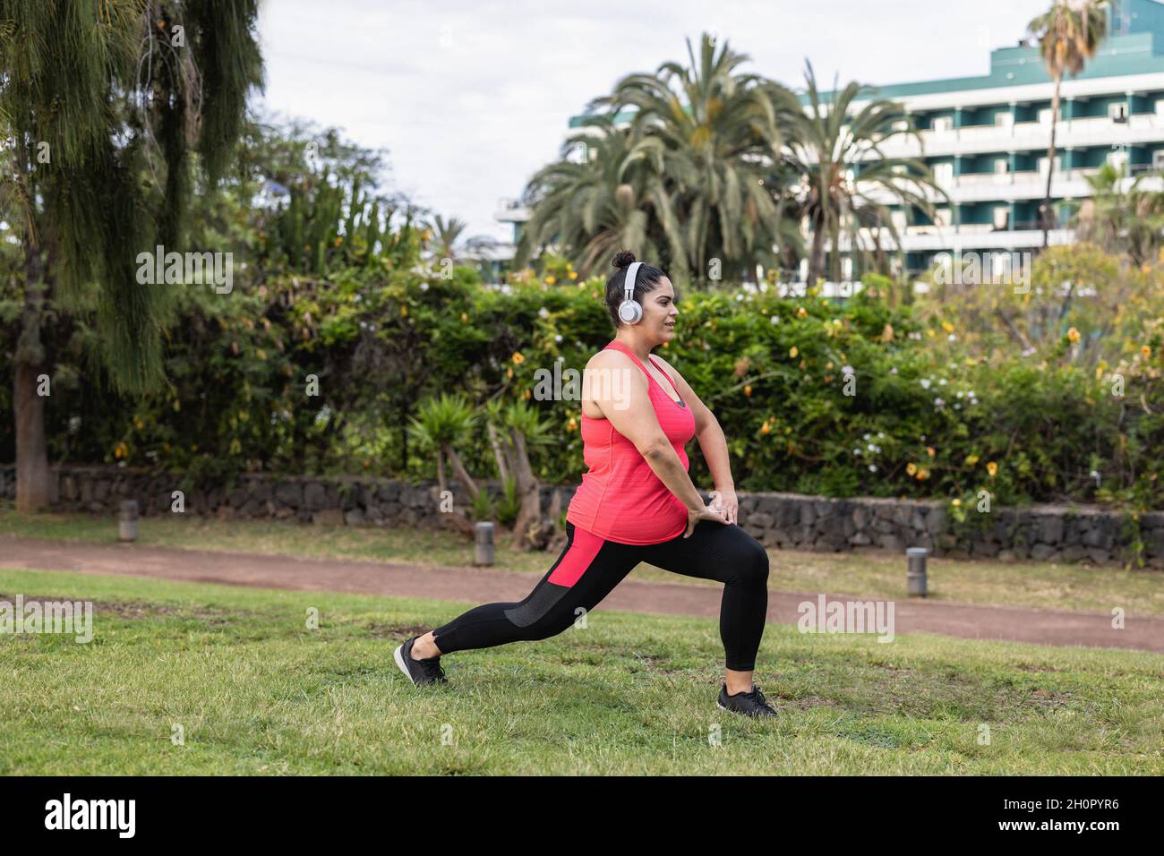 Stretch Routine For Plus Size Plus size woman doing stretching day routine outdoor at city park ...