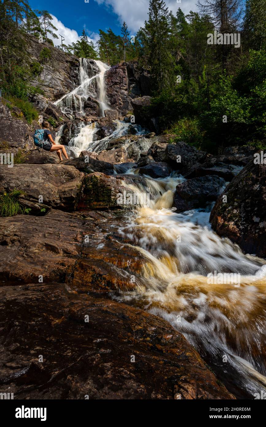 Tourist admires Elgafossen - Algafallet Waterfall shared between Sweden and Norway Stock Photo