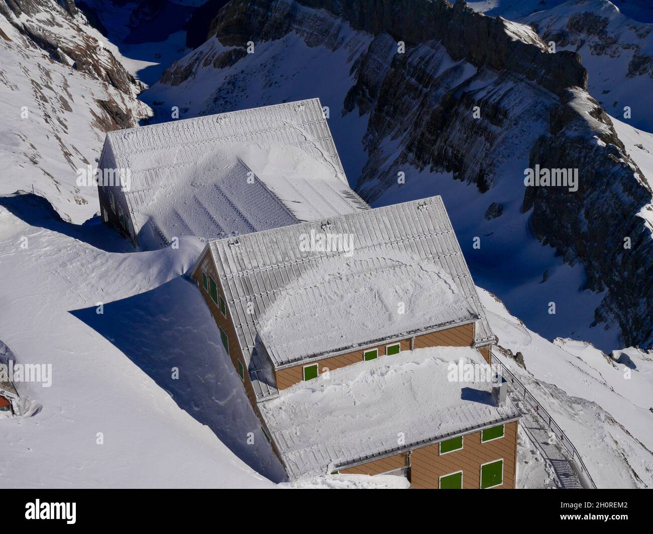 Aerial view of Berggasthaus Alter Saentis in winter seen from the mountain station of Saentis cable car. Appenzell, Switzerland. Stock Photo