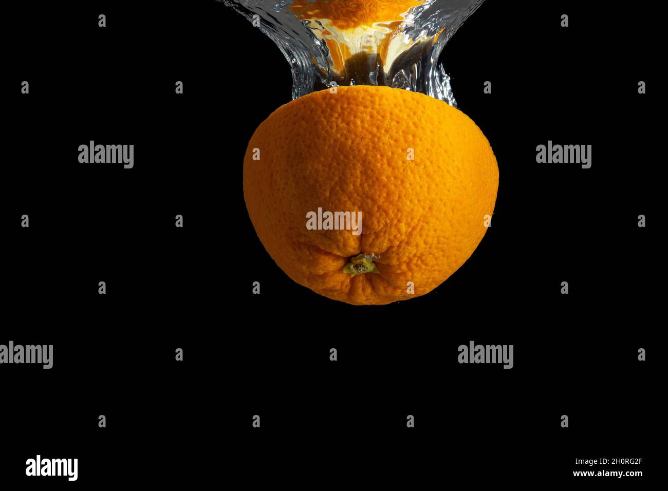 Fresh sliced orange fruit in water splash isolated on black background ...