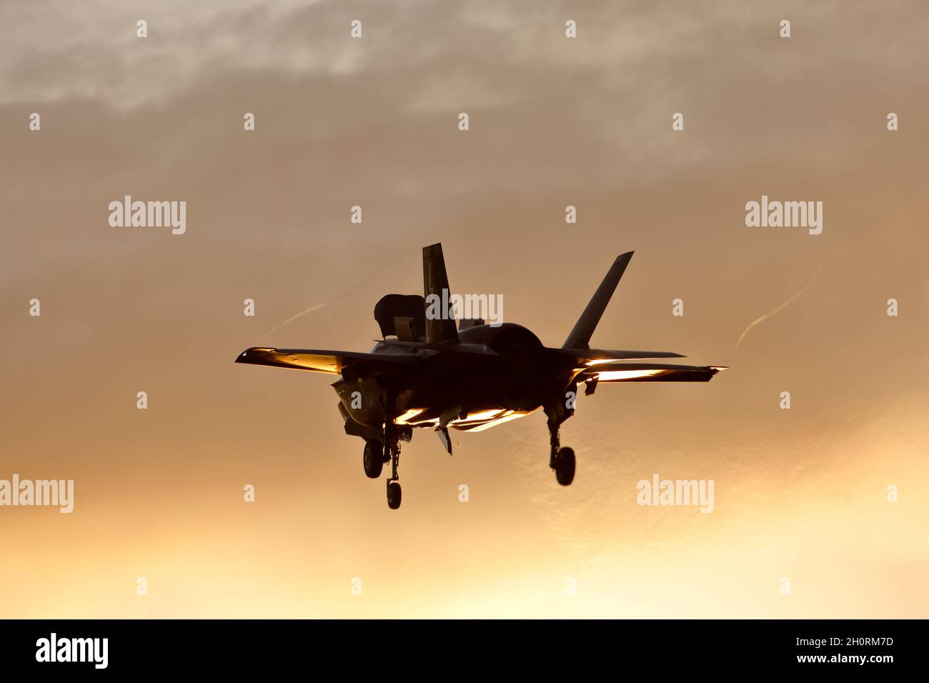 Lockheed Martin F-35B Lightning II hovering at sunset, at RAF Marham in Norfolk, England. Stock Photo