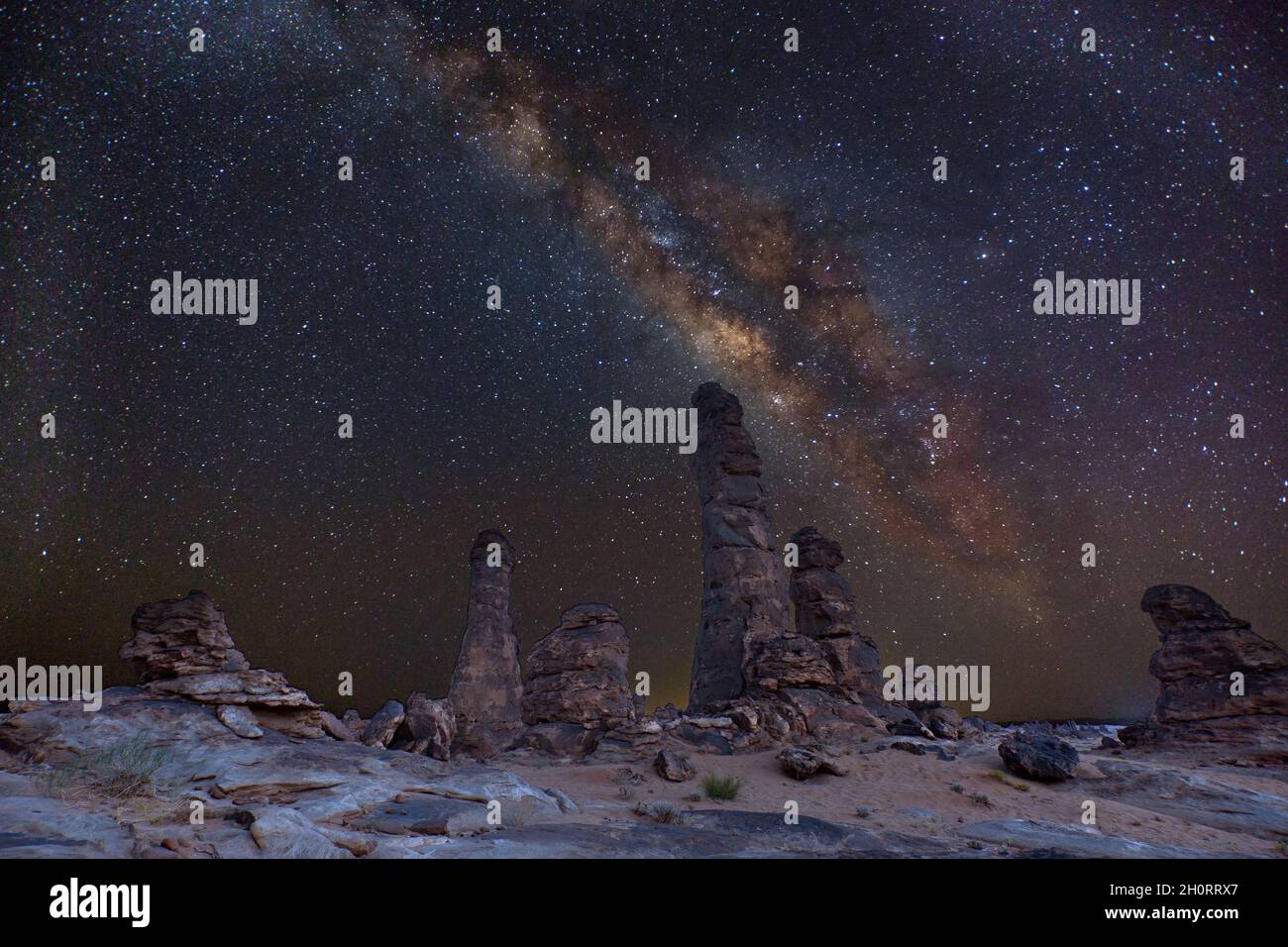 Milky way over rock formations in the desert at night, Saudi Arabia Stock Photo