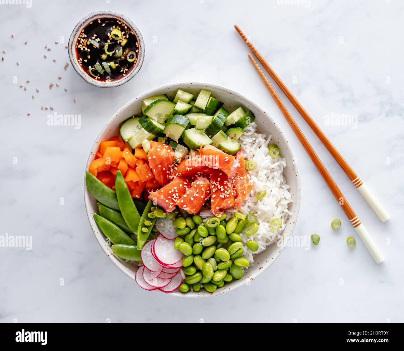 Salmon poke bowl with rice, edamame beans, cucumber, radish, mange tout