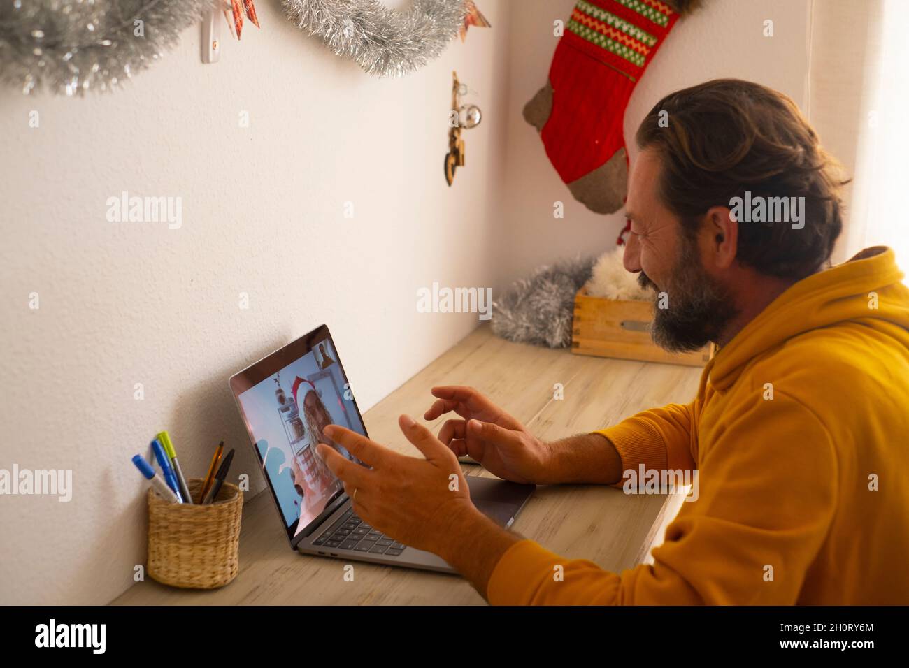Mature man smile and calling cheerful woman to celebrate christmas together using video call conference application on laptop computer with wireless i Stock Photo