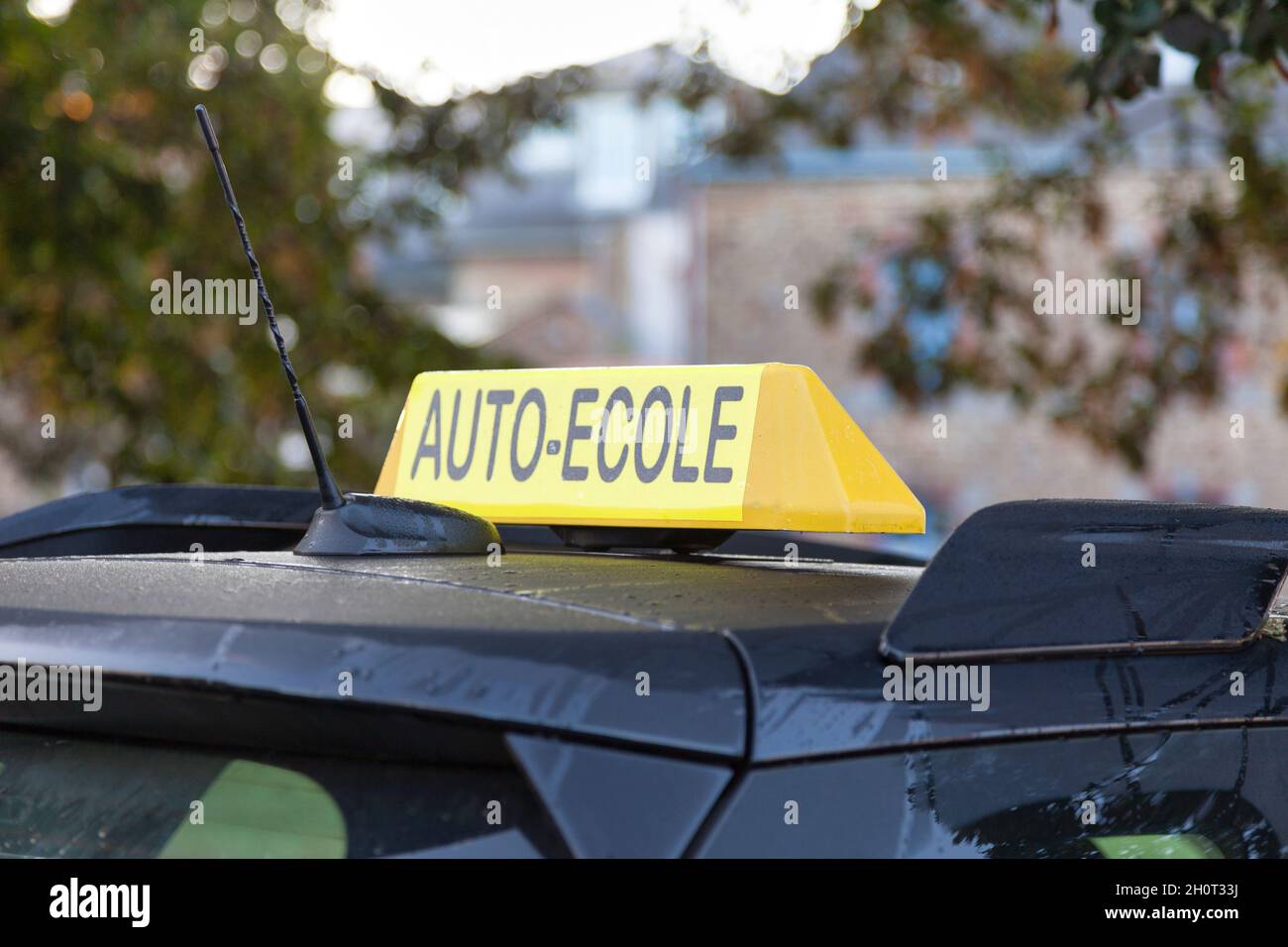 Yellow car roof sign with written in it in French 'Auto-École', meaning in English 'Driving school'. Stock Photo
