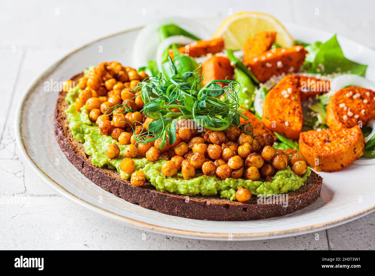 Toast with guacamole and crispy chickpeas, close-up. Vegan food concept. Stock Photo