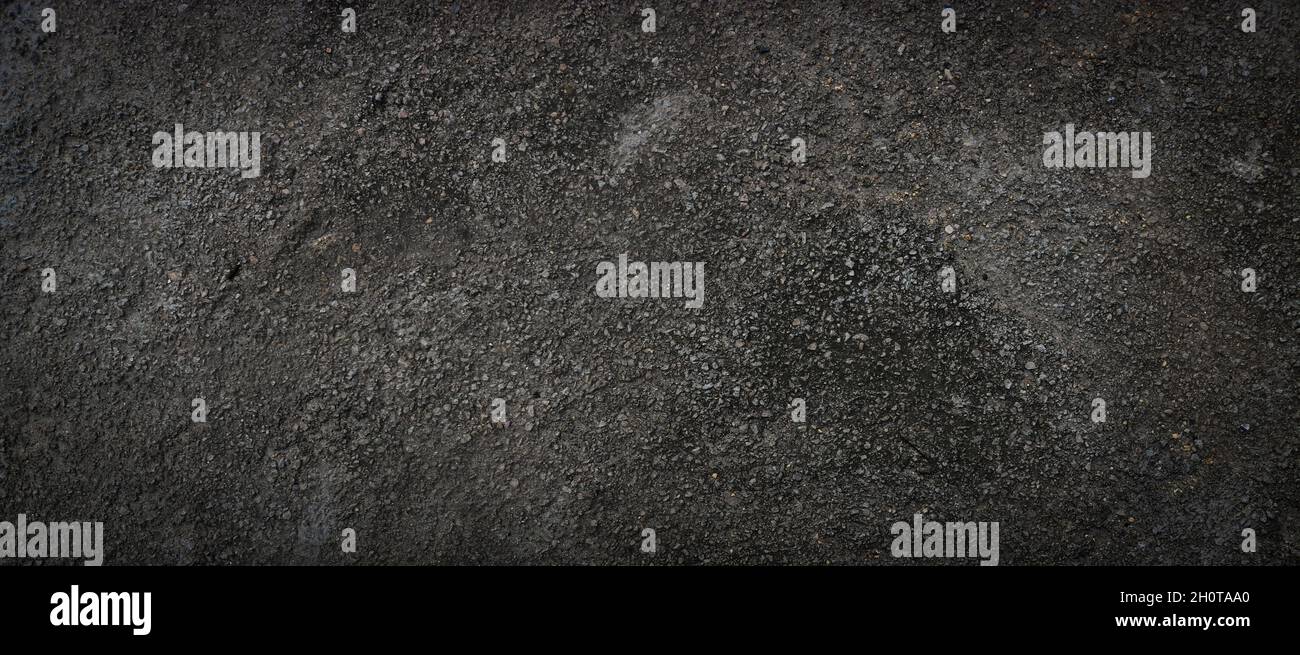 Black rough concrete surface, dark scary background, grunge texture. Stock Photo