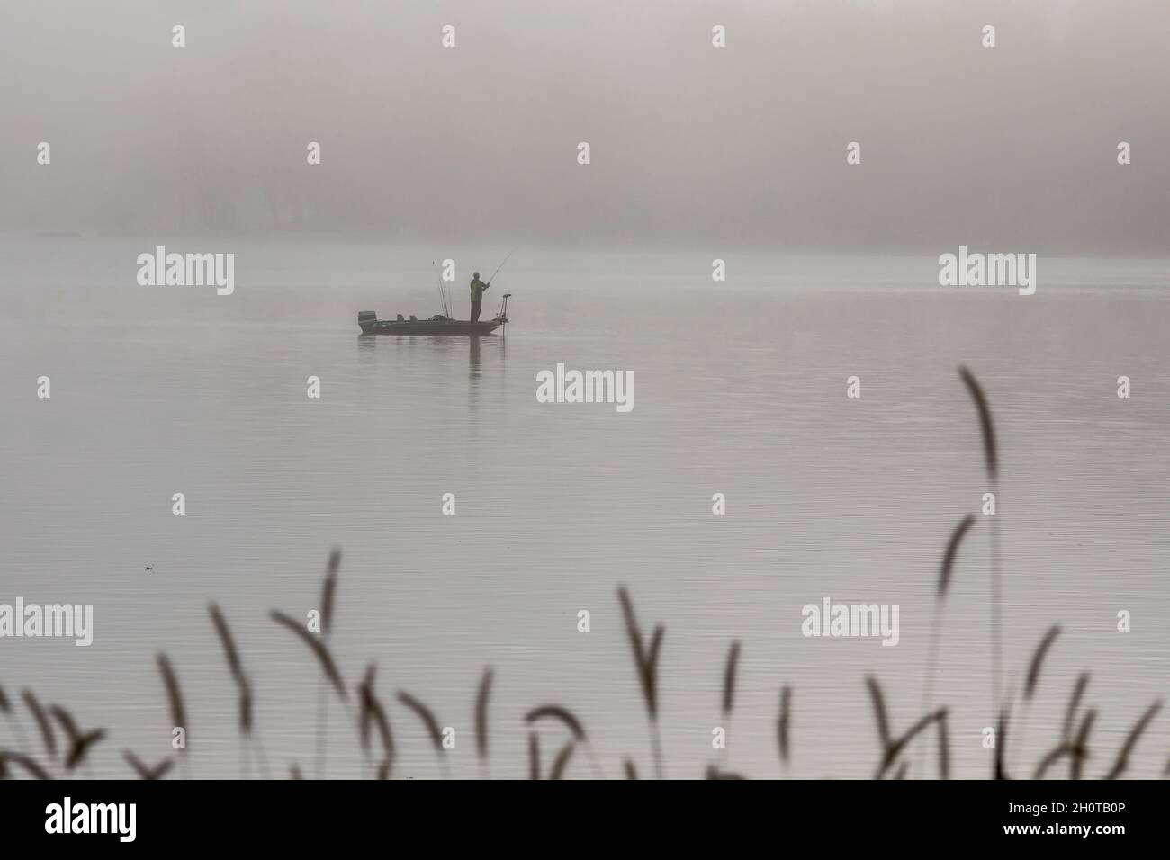 Plainwell, Michigan A man fishes from a boat on Pine Lake in the