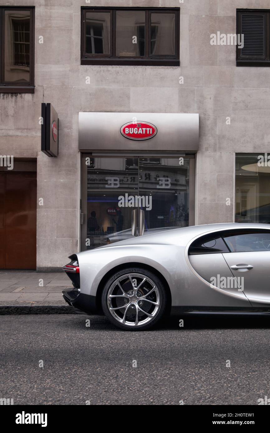 Silver Bugatti Chiron supercar parked near a Bugatti dealership in