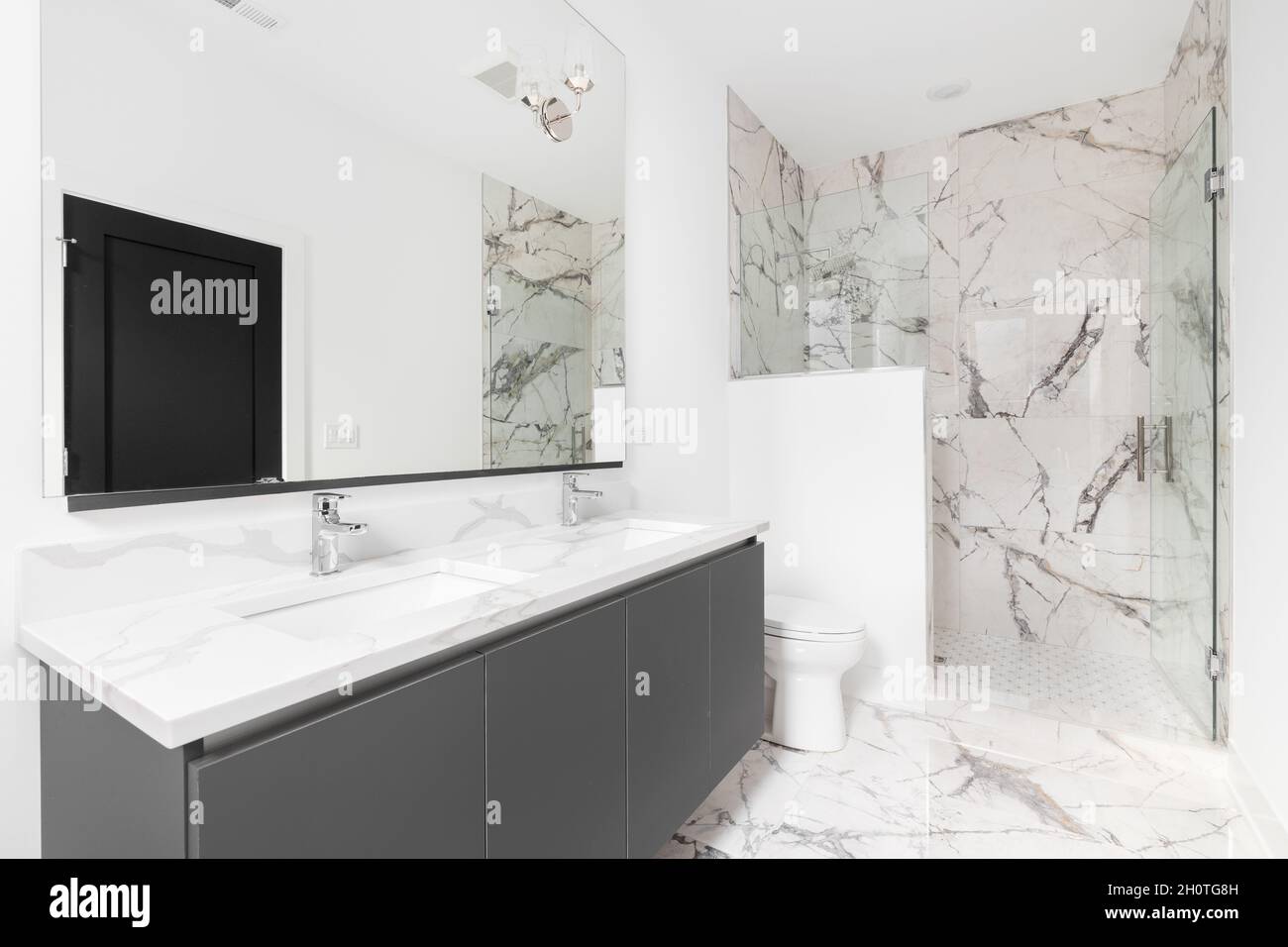 A luxurious bathroom with a grey vanity cabinet, white marble ...