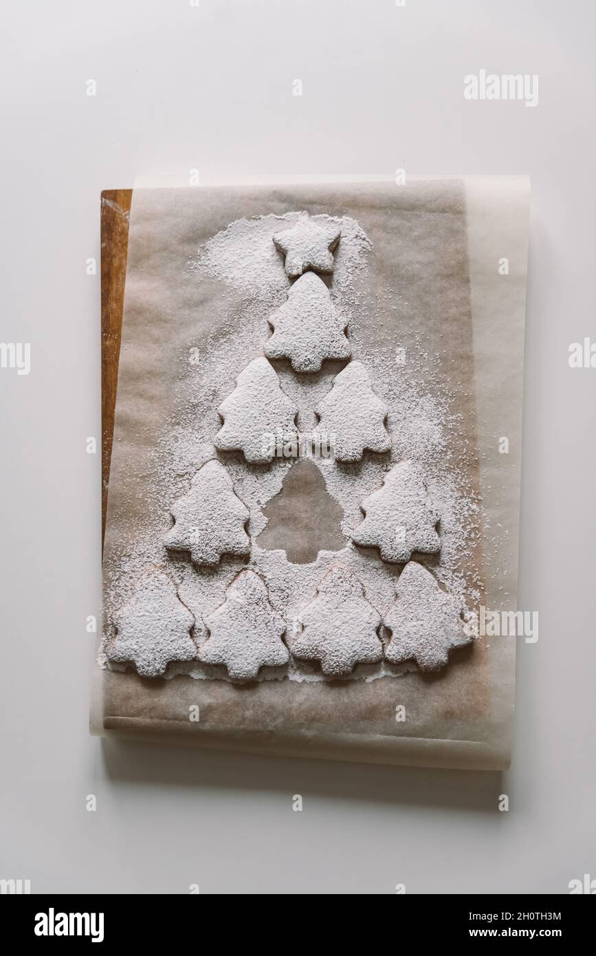 Gingerbread Christmas tree sprinkled with powdered sugar on parchment Stock Photo