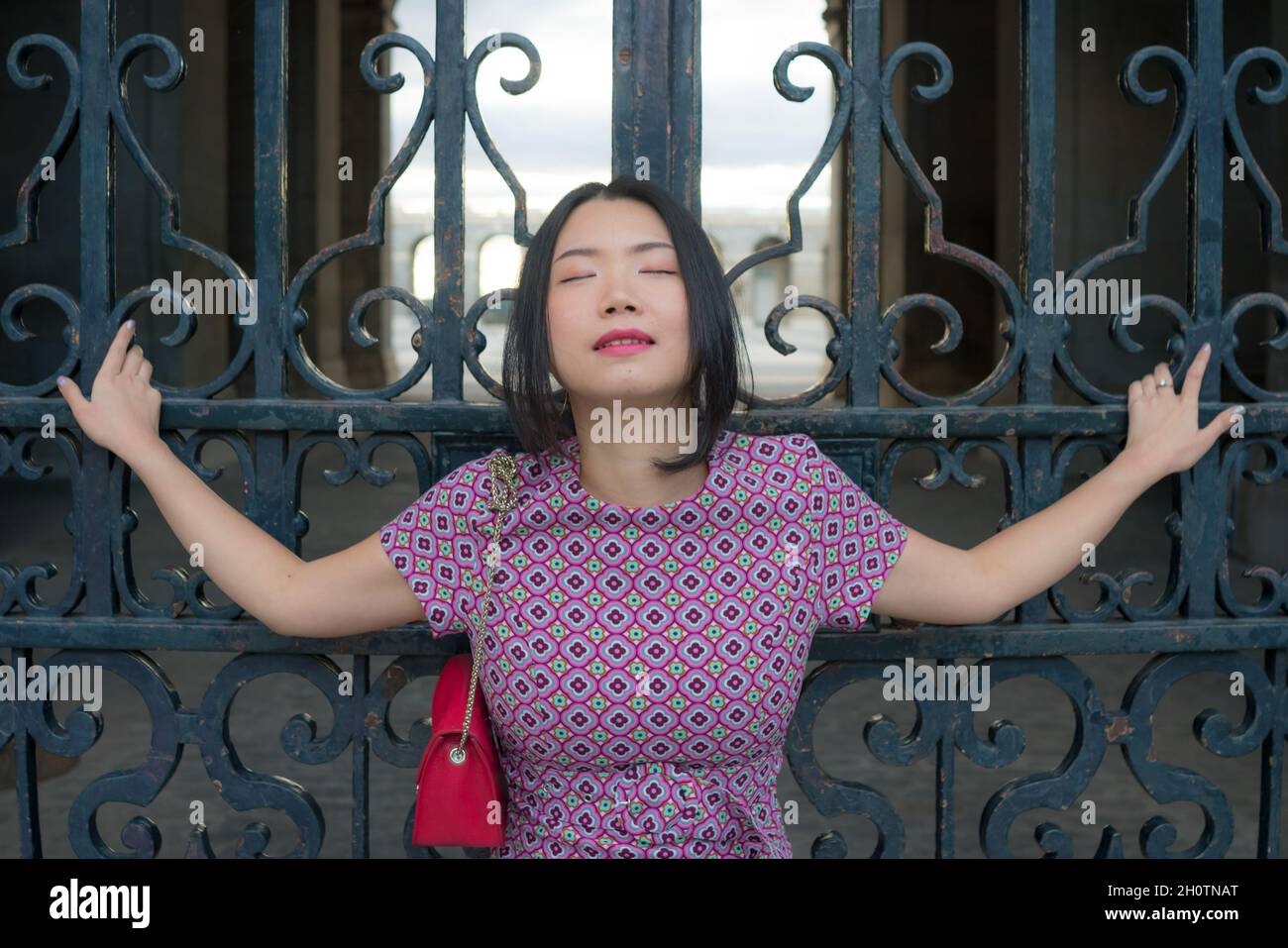 urban lifestyle outdoors portrait of young happy and beautiful Asian Korean woman in sweet Autumn dress enjoying Madrid city tour relaxed and cheerful Stock Photo