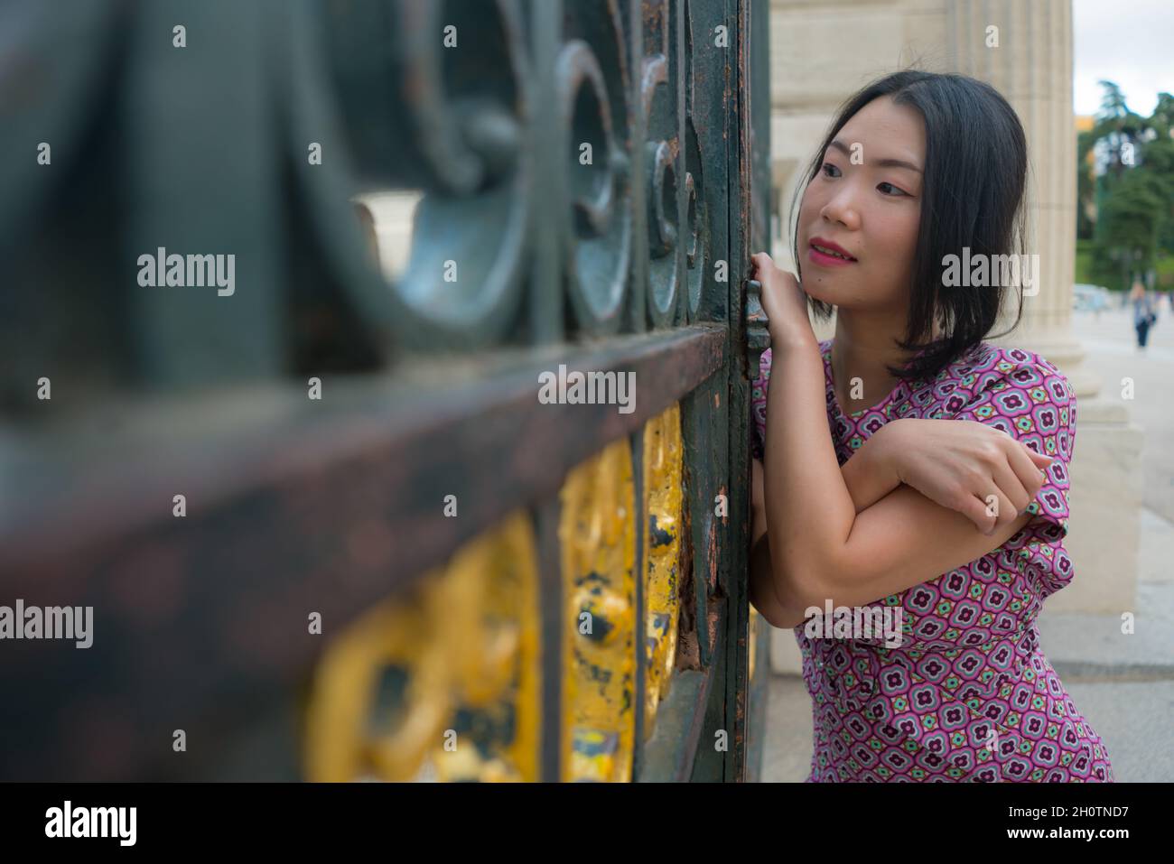 urban lifestyle outdoors portrait of young happy and beautiful Asian Korean woman in sweet Autumn dress enjoying Madrid city tour relaxed and cheerful Stock Photo