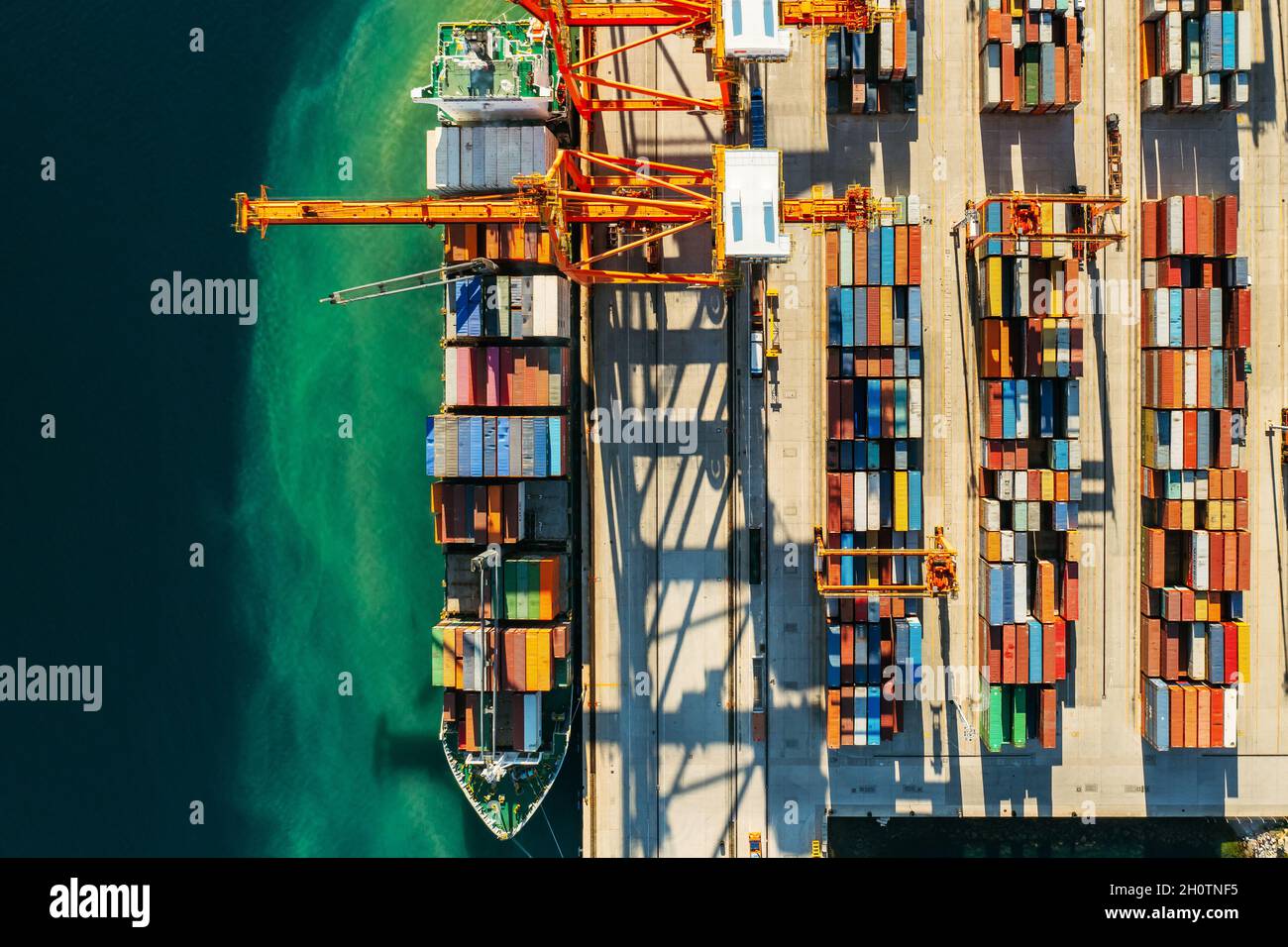 Containers in international shipping dock waiting to import or export and transportation. Top view of loading containers on the ship in the port Stock Photo