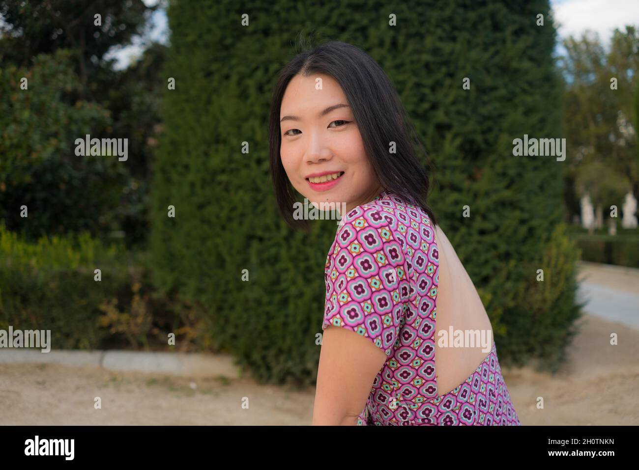 urban lifestyle outdoors portrait of young happy and beautiful Asian Korean woman enjoying Madrid city tour relaxed and cheerful walking in the park i Stock Photo