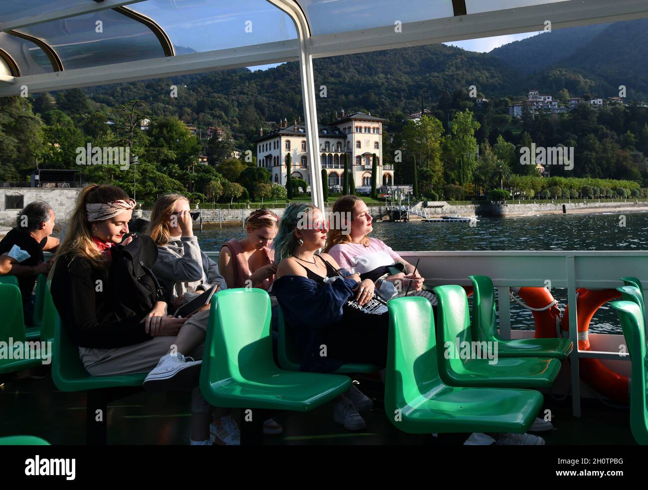 Tourists girls women on boat Varenna, Lake Como, Italy Stock Photo